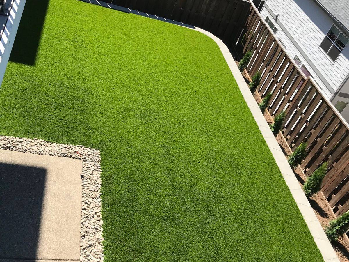 Artificial turf edge meeting a gravel border and concrete walkway on a Portland, OR installation